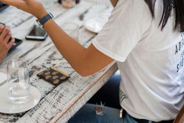 A young woman engaging in a serious conversation at a cafe, illustrating a discussion on how to handle difficult employee situations. She gestures expressively, emphasizing the importance of effective communication in resolving workplace conflicts.